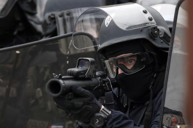 French cop aiming flash ball gun
