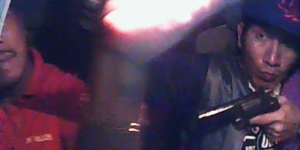 Still from video showing robber with gun