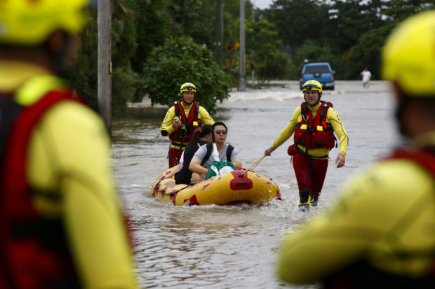  Australian leader tours floods where 2 men reported missing