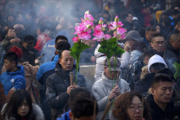 Asia welcomes year of the pig with banquets, temple visits