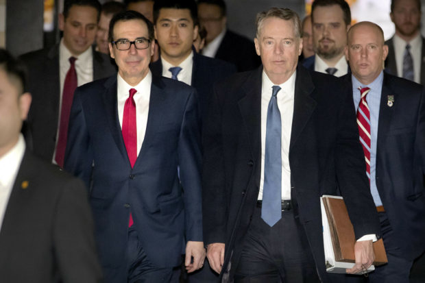 U.S. Treasury Secretary Steven Mnuchin, left, and U.S. Trade Representative Robert Lighthizer walk together as they leave their hotel in Beijing, Friday, Feb. 15, 2019. U.S. and Chinese negotiators opened talks Thursday on a sprawling trade dispute as Beijing reported its January exports rebounded despite President Donald Trump's tariff hikes. (AP Photo/Mark Schiefelbein)