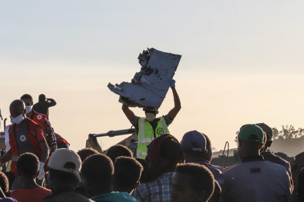 A man carries a piece of debris on his head at the crash site of a Nairobi-bound Ethiopian Airlines flight near Bishoftu, a town some 60 kilometres southeast of Addis Ababa, Ethiopia, on March 10, 2019. - A Nairobi-bound Ethiopian Airlines Boeing crashed minutes after takeoff from Addis Ababa on March 10, killing all eight crew and 149 passengers on board, including tourists, business travellers, and "at least a dozen" UN staff. (Photo by Michael TEWELDE / AFP)