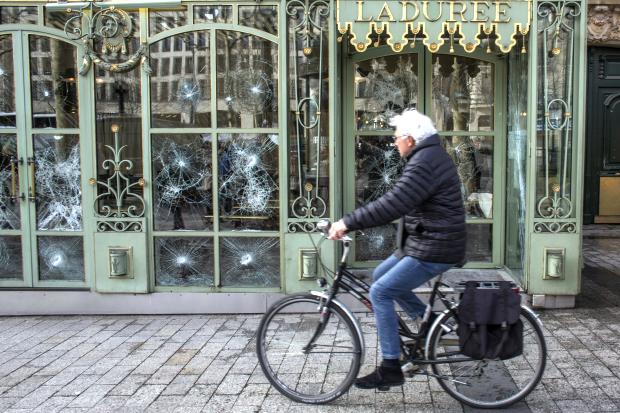 Cyclist goes past Laduree in Paris