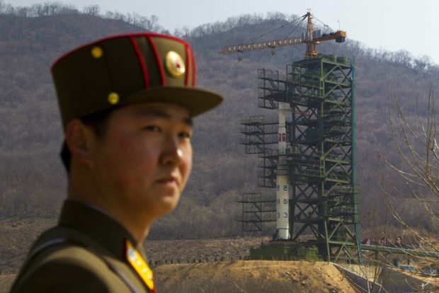 FILE - In this April 8, 2012, file photo, a soldier stands in front of the Unha-3 rocket at a launching site in Tongchang-ri, North Korea. North Korea is reportedly restoring facilities at its long-range rocket launch site that it had dismantled as part of disarmament steps last year. A major South Korean newspaper reports that the country's spy service gave such an assessment to lawmakers in a private briefing on Tuesday. (AP Photo/David Guttenfelder, File)