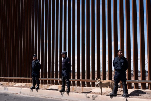 Migrants break border gate, force their way into Mexico