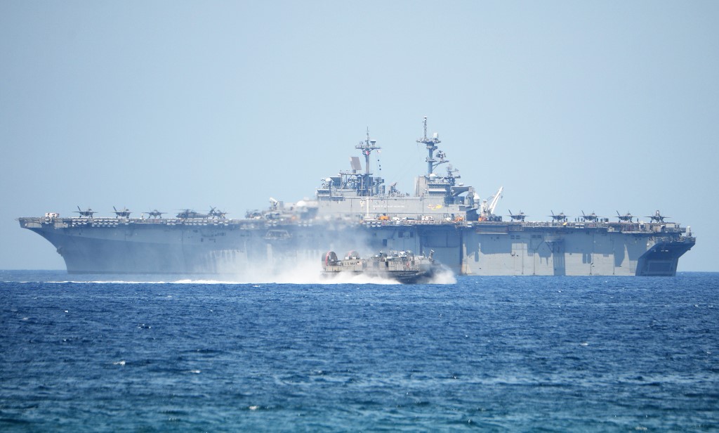 A US Navy hover craft speeds past the USS Wasp, US Navy multipurpose amphibious assault ship, during the amphibious landing exercises as part of the annual joint US-Philippines military exercise on the shores of San Antonio town, facing the South China sea, Zambales province on April 11, 2019. (Photo by TED ALJIBE / AFP) balikatan war games
