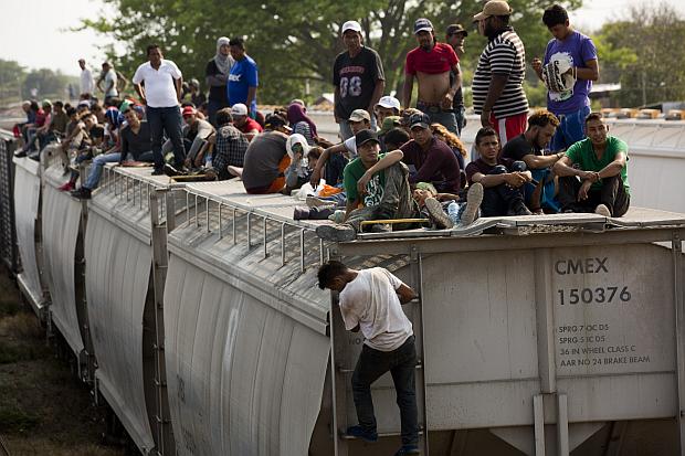 Central American migrants on top of parked truck