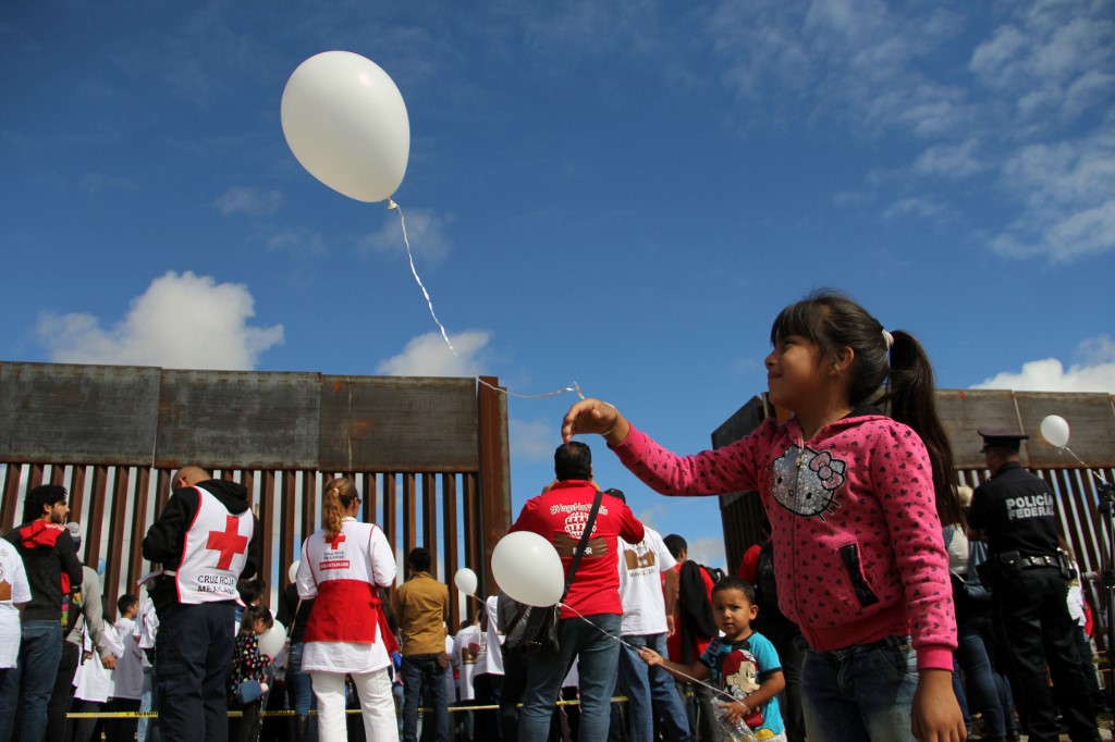 Members of migrant families living in the US and Mexico release balloons after taking part in an event called "Abrazos No Muros" (Hugs, not walls) promoted by the Border etwork of Human Rights organization in the border line between Sunland Park, New Mexico State, United States and Ciudad Juarez, state of Chihuahua, Mexico, on 13 October 2018. (Photo by HERIKA MARTINEZ / AFP)