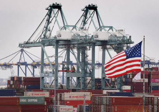 Chinese shipping containers are stored beside a US flag after they were unloaded at the Port of Los Angeles in Long Beach, California on May 14, 2019. - Global markets remain on red alert over a trade war between the two superpowers China and the US, that most observers warn could shatter global economic growth, and hurt demand for commodities like oil. (Photo by Mark RALSTON / AFP)