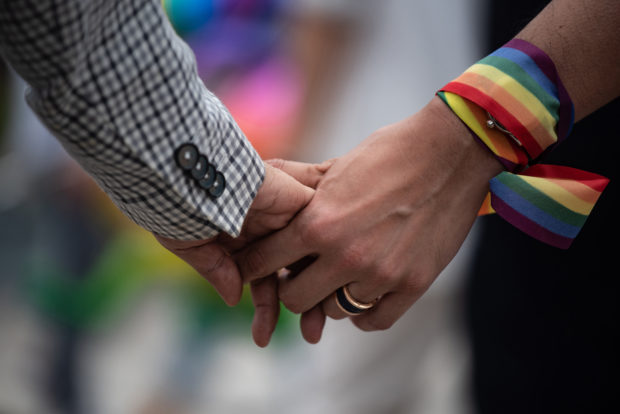 Same-sex couple holding hands, for story: Presidential candidates weigh in on civil union and divorce