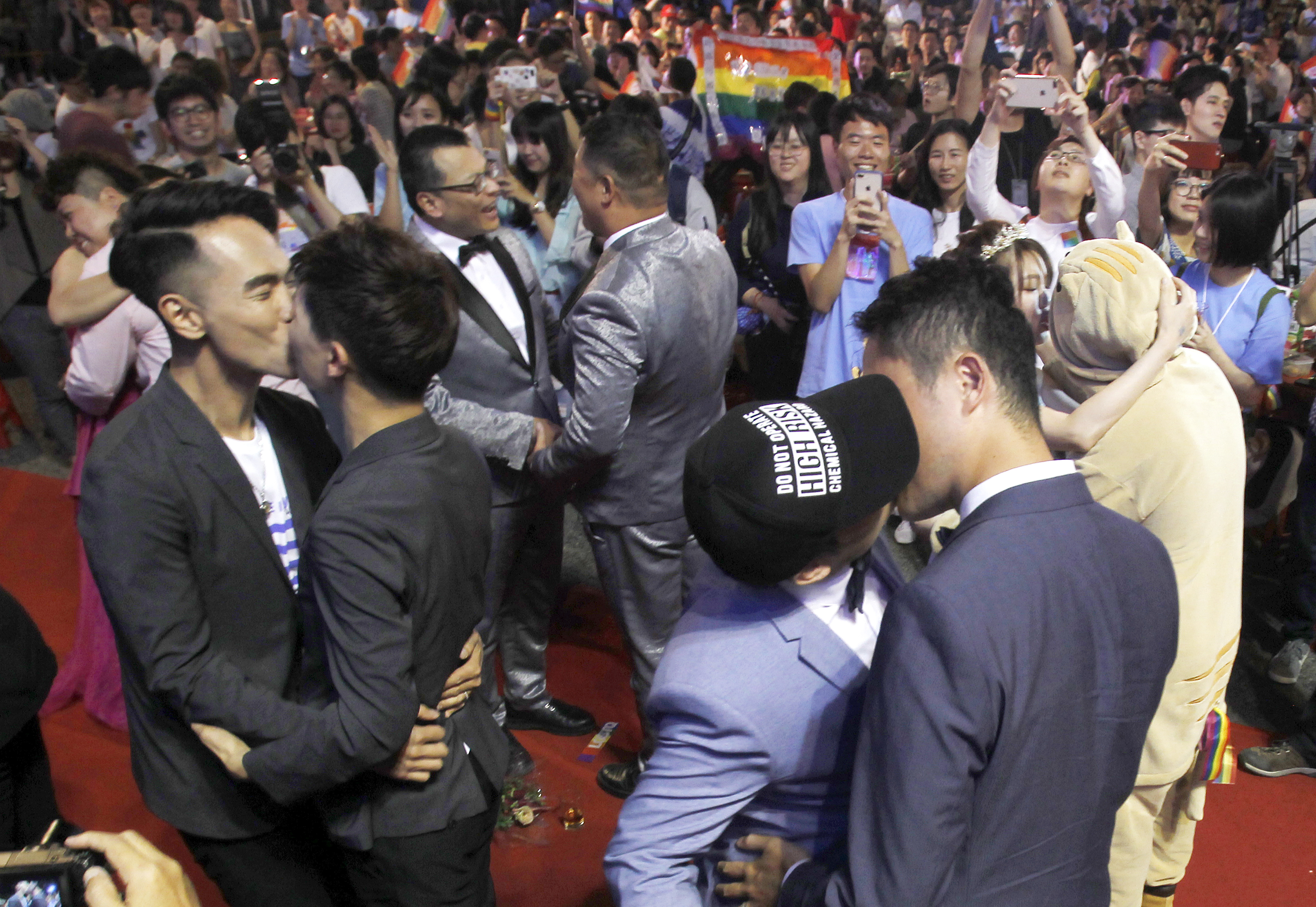 Taiwanese same-sex couples kiss at their wedding party in Taipei, Taiwan, Saturday, May 25, 2019. Taiwan became the first place in Asia to allow same-sex marriage last week. Hundreds of same-sex couples in Taiwan rushed to get married Friday, the first day a landmark decision that legalized same-sex marriage took effect. (AP Photo/Chiang Ying-ying)