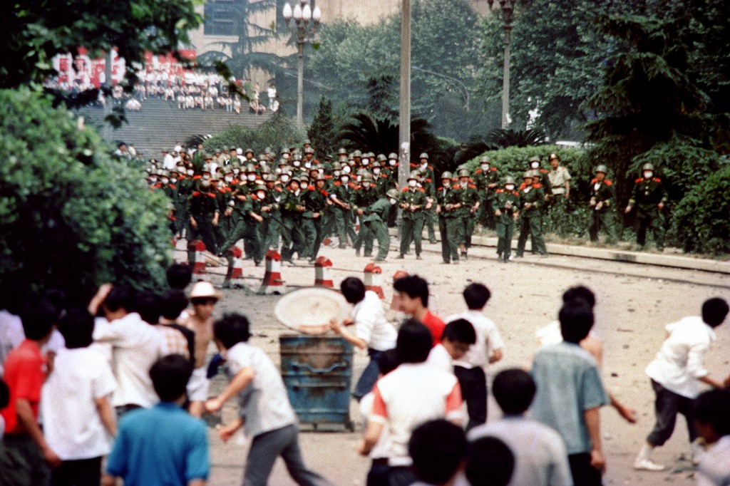 (FILES) This file photo taken on June 4, 1989 shows Chinese citizens and students hurling stones at troops during rioting following the proclamation of martial law in the city of Chengdu, capital of China's Sichuan province. - While Beijing was the epicentre of the 1989 student-led protests, which were violently crushed by armed forces in June with hundreds or even thousands killed, large-scale demonstrations erupted all around China. (Photo by - / AFP) / To go with AFP story China-politics-Tiananmen, FOCUS by Eva Xiao and Elizabeth Law
