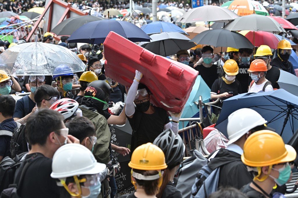 Protesters occupy the roads near the Legislative Council and government headquarters in Hong Kong on June 12, 2019. - Tens of thousands of protesters paralysed central Hong Kong, blocking major roads in a defiant show of strength against government plans to allow extraditions to China. By late morning, with crowds continuing to swell, officials in the Legislative Council (Legco) said they would delay the second reading of the bill "to a later date". (Photo by Anthony WALLACE / AFP)