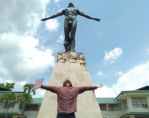 Thomas John Tenedero in front of the UPLB Oblation