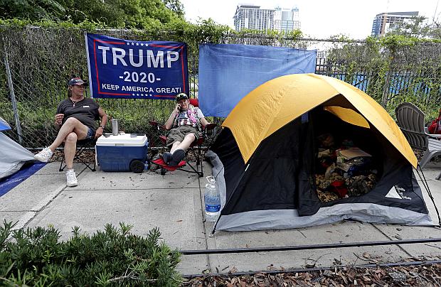 Anna Connelly, left, and Jeanna Gullett supporters of President Donald Trump, make camp Monday, June 17, 2019, in Orlando, Florida as they wait to attend a rally for the president on Tuesday evening. (Photo by JOHN RAOUX / AP)