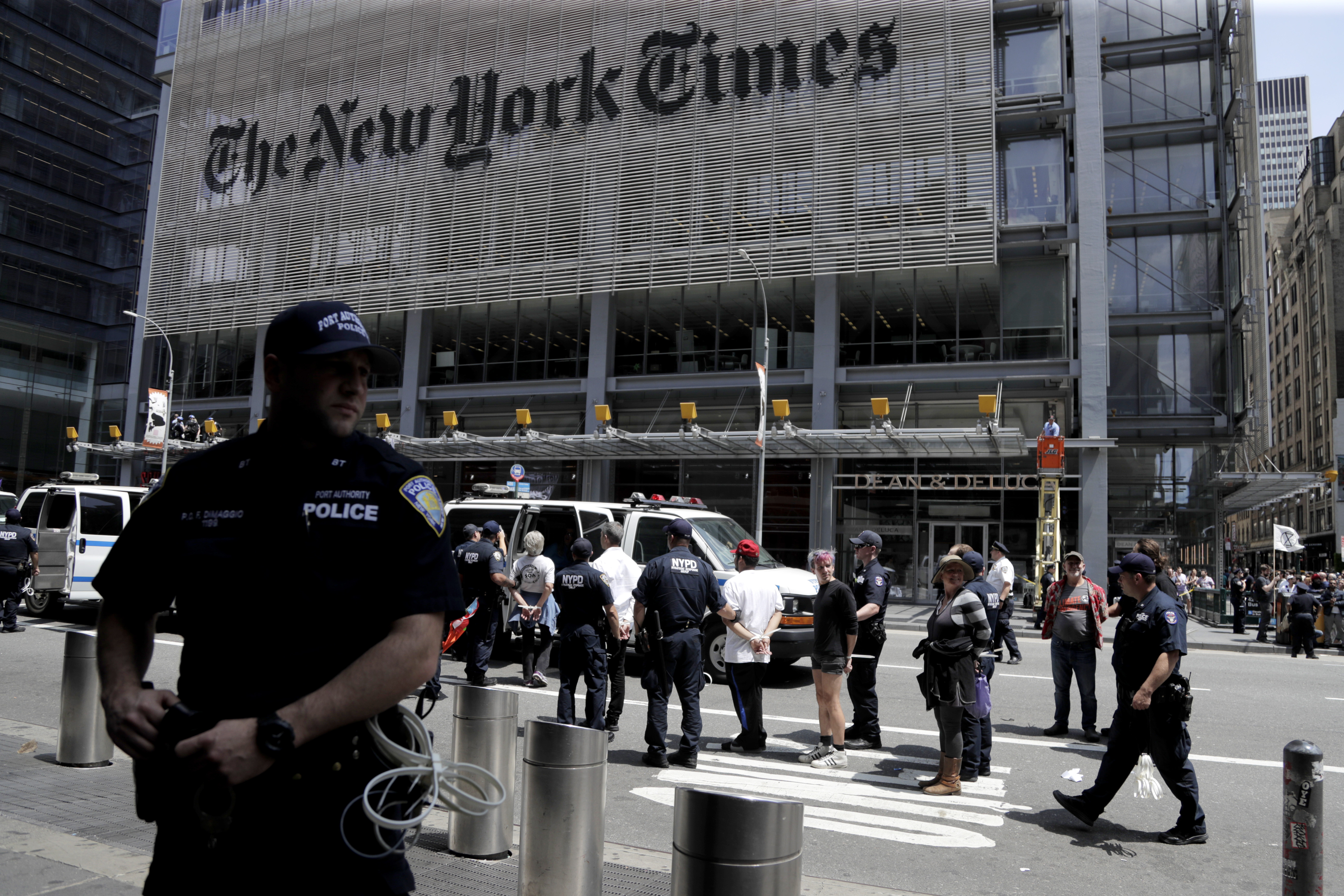 New York Police officers take into custody activists during a climate change rally outside of the New York Times building, Saturday, June 22, 2019, in New York. Activists blocked traffic along 8th Avenue during a sit-in to demand coverage of climate change by the newspaper. (AP Photo/Julio Cortez)