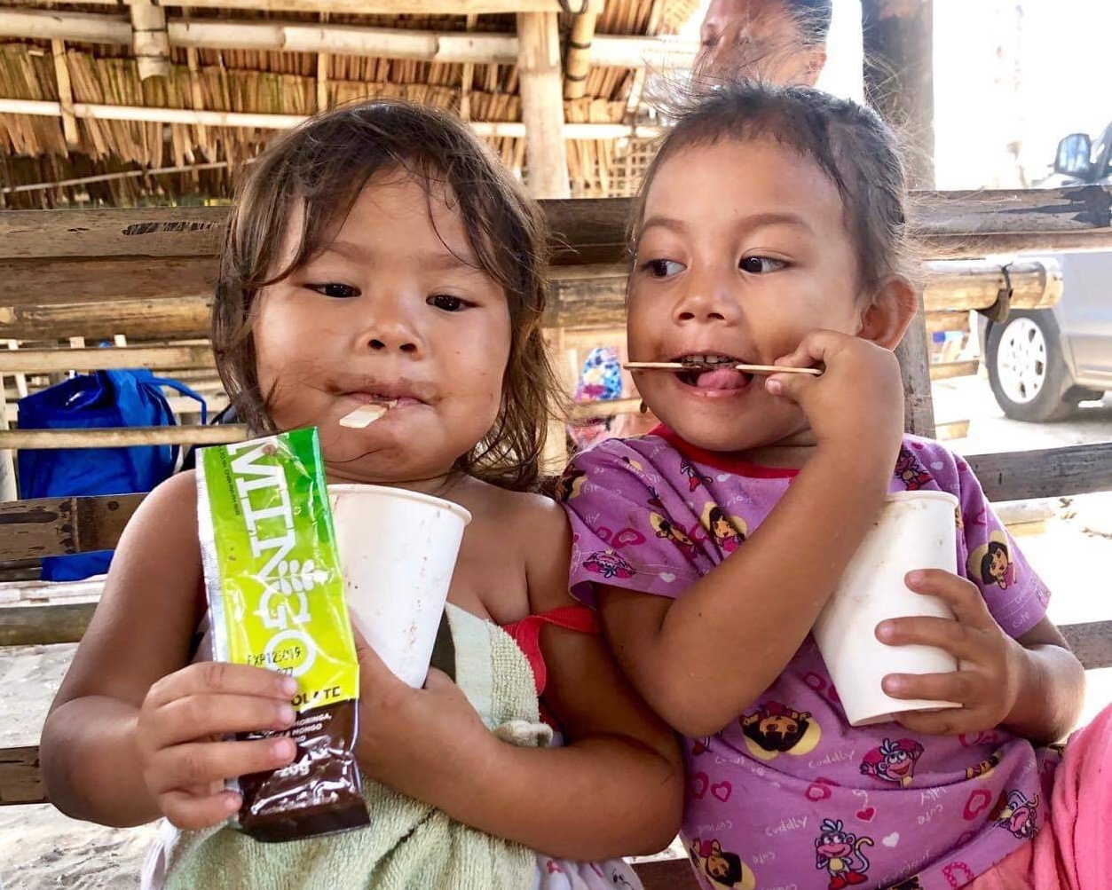 Children at a village in Bacolod City get a taste of nutritious mingo meals courtesy of Negros Volunteers for Change which aims to produce 10 million packs of these meals by January 2020. CARLA P. GOMEZ