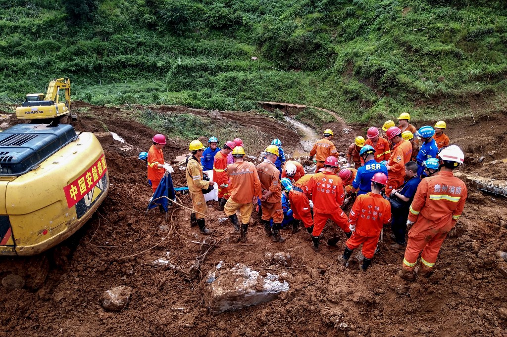 This photo taken on July 24, 2019 shows rescuers working at the site of a landslide in Liupanshui in China's southwestern Guizhou province. - The death toll in a landslide that buried a village in southwest China rose to 20 on July 26, with 25 people still missing three days after the disaster, state media said. (Photo by STR / AFP) / China OUT