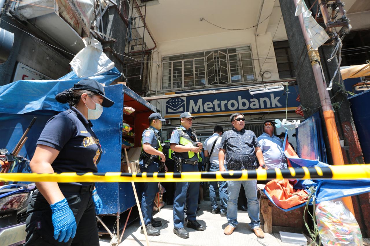 Police officers maintain a security perimeter outside a metrobank brach in sto cristo, binondo, manila after 7 individuals rob the bank on thursday.-inquirer/grig c. montegrande