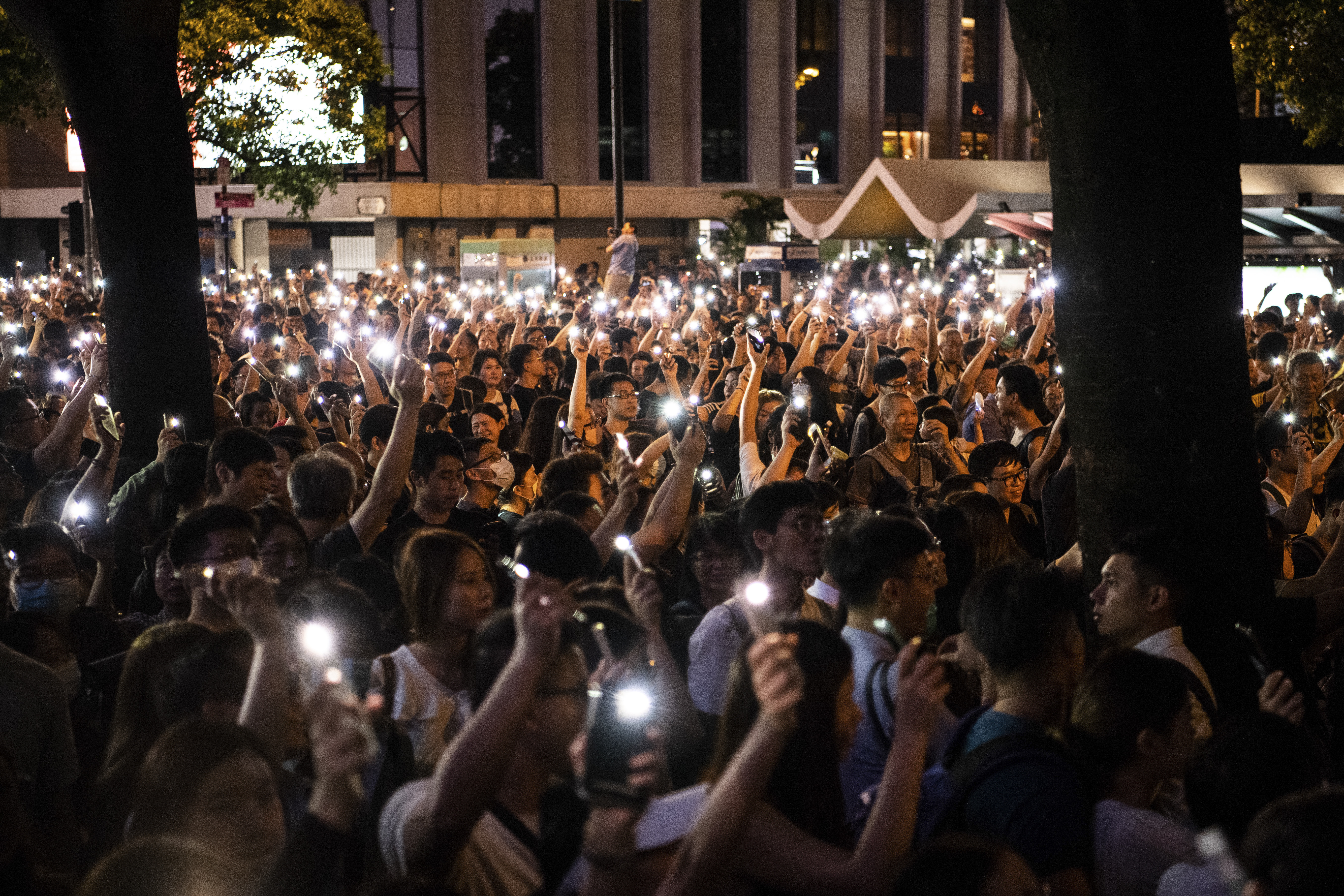 People wave their cell phone lights at a protest held by civil servants in the Central District of Hong Kong on August 2, 2019, in the latest opposition to a planned extradition law that was quickly evolved into a wider movement for democratic reforms. - Hong Kong civil servants on August 2 night kicked off a weekend of anti-government protests and unsanctioned rallies in defiance of warnings from China and after a prominent independence campaigner was arrested. (Photo by Laurel Chor / AFP)