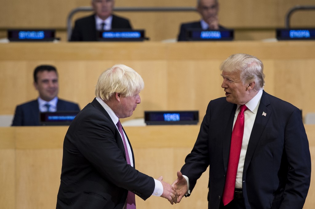 (FILES) In this file photo taken on September 18, 2017 British Foreign Secretary Boris Johnson (L) and US President Donald Trump greet before a meeting on United Nations Reform at UN headquarters in New York on September 18, 2017. - Prime Minister Boris Johnson makes his debut on the global stage at the G7 summit this weekend, August 24, 2019, where all eyes will be on his chumminess with US President Donald Trump. (Photo by Brendan Smialowski / AFP)