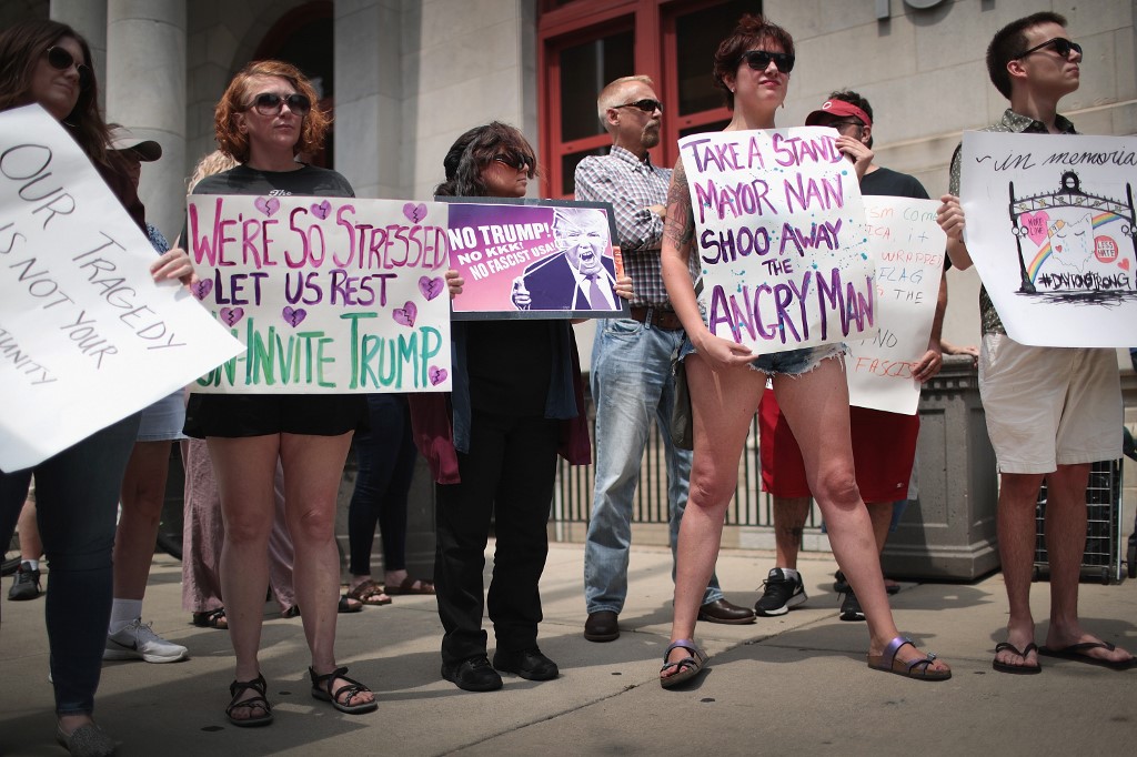 DAYTON, OHIO - AUGUST 06: Demonstrators outside of the Dayton City Hall protest a planned visit of President Donald Trump on August 06, 2019 in Dayton, Ohio. Trump is scheduled to visit the city on Wednesday as residents recover from Sunday Morning's mass shooting in the Oregon District. Nine people were killed and another 27 injured when a gunman identified as 24-year-old Connor Betts opened fire with a AR-15 style rifle in the popular entertainment district. Betts was subsequently shot and killed by police. The shooting happened less than 24 hours after a gunman in Texas opened fire at a shopping mall killing 22 people.   Scott Olson/Getty Images/AFP