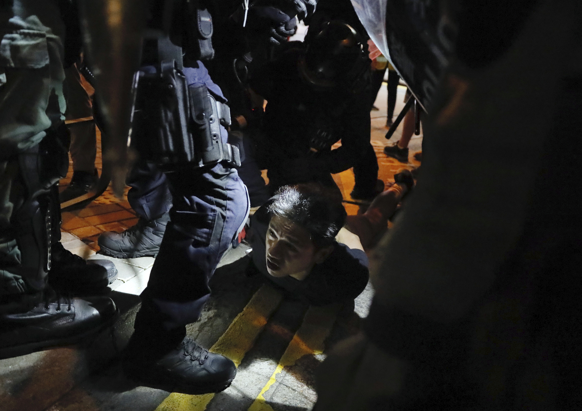A man is detained by police during street protests in Hong Kong on Saturday, Aug. 3, 2019. Hong Kong protesters removed a Chinese national flag from its pole and flung it into the city's iconic Victoria Harbour on Saturday, and police later fired tear gas at demonstrators after some of them vandalized a police station. (AP Photo/Kin Cheung)