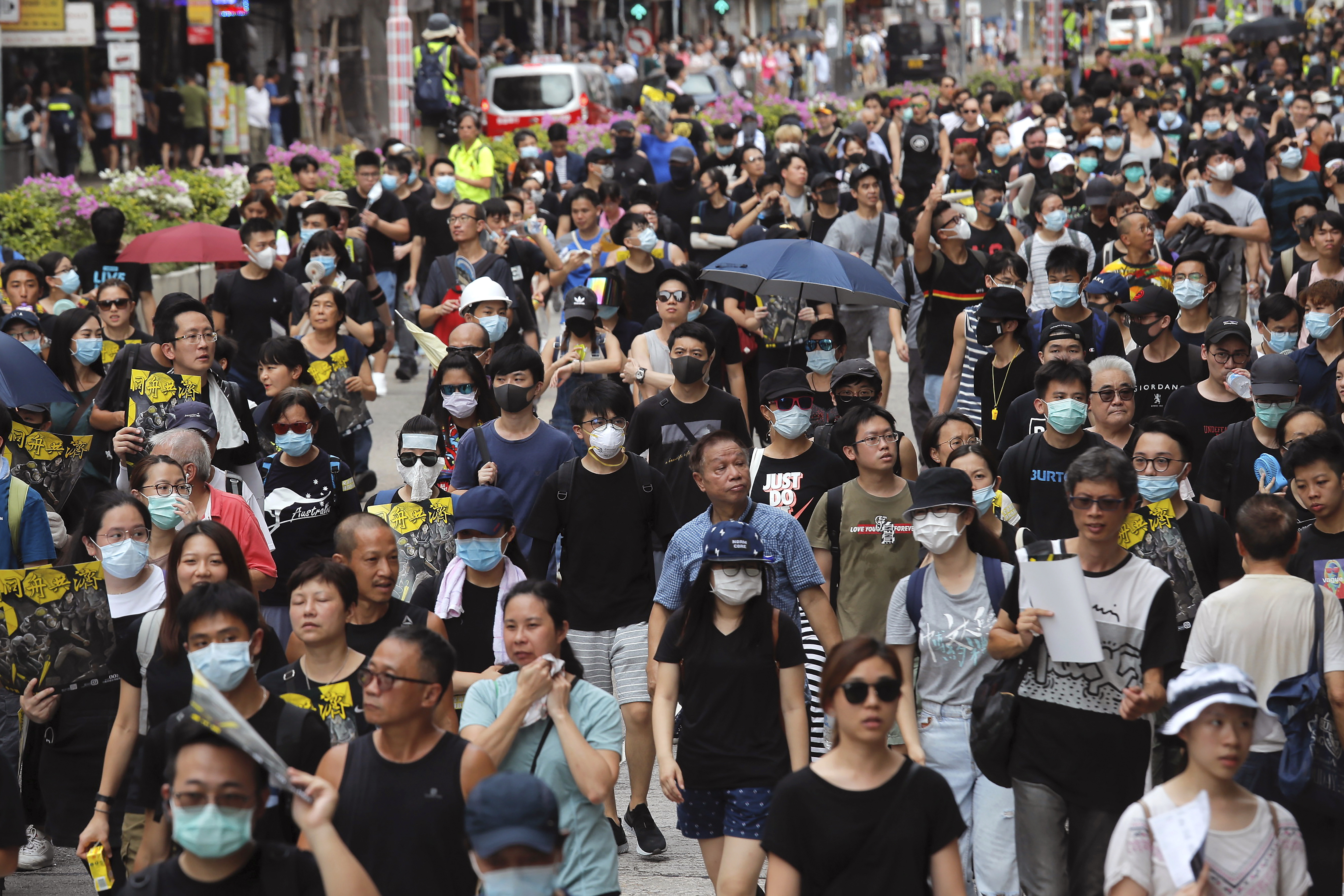 Protesters and residents take part in the anti-extradition bill protest march at Shum Shui Po in Hong Kong, Sunday, Aug. 11, 2019. Separate protests were being held in two parts of Hong Kong on Sunday in a continuing series of demonstrations that have generally started peacefully but often ended in violent clashes with police. (AP Photo/Kin Cheung)
