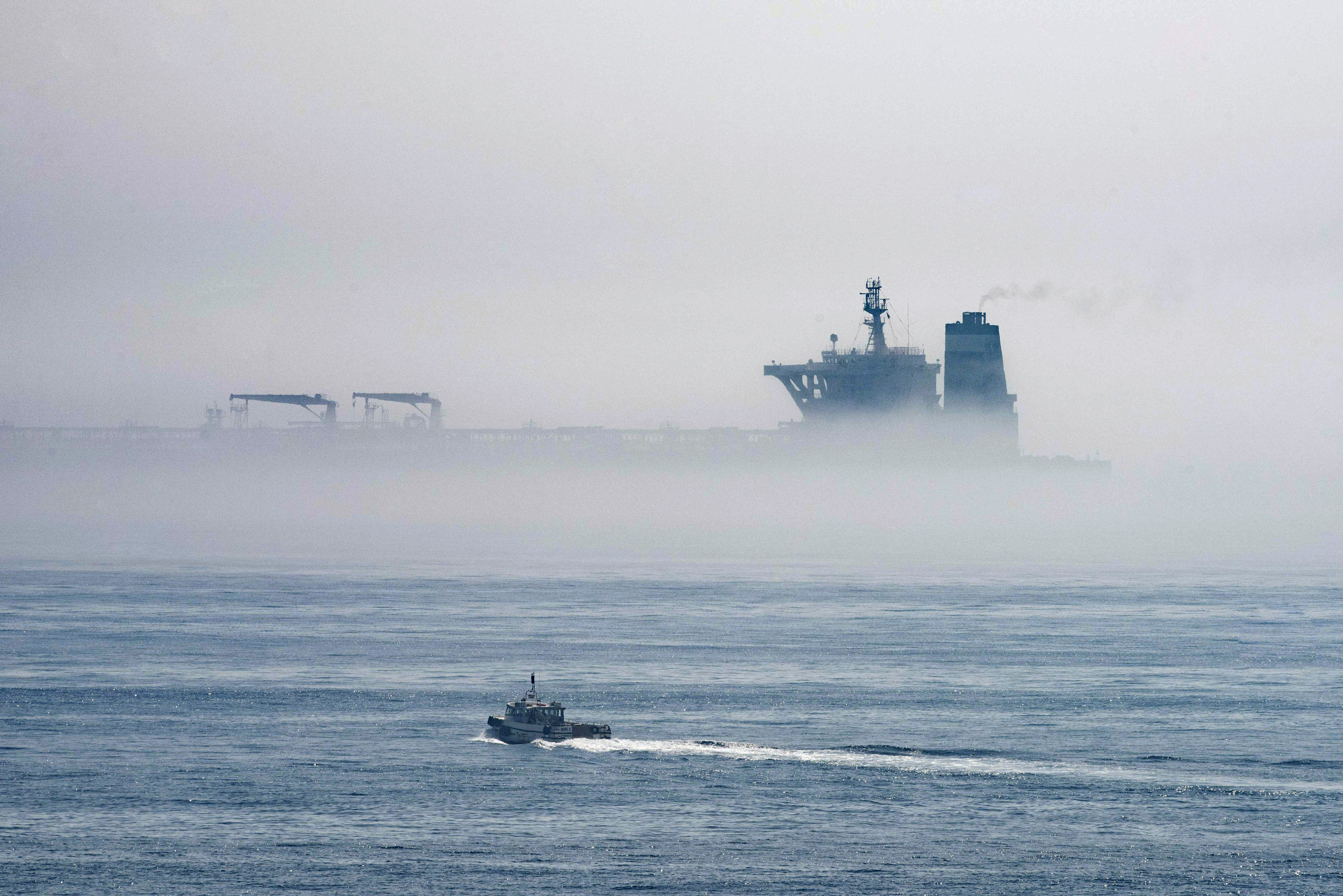 A view of the Grace 1 supertanker is seen through the sea fog, in the British territory of Gibraltar, Thursday, Aug. 15, 2019, seized last month in a British Royal Navy operation off Gibraltar.  The United States moved on Thursday to halt the release of the Iranian supertanker Grace 1, detained in Gibraltar for breaching EU sanctions on oil shipments to Syria, thwarting efforts by authorities in London and the British overseas territory to defuse tensions with Tehran. (AP Photo/Marcos Moreno)