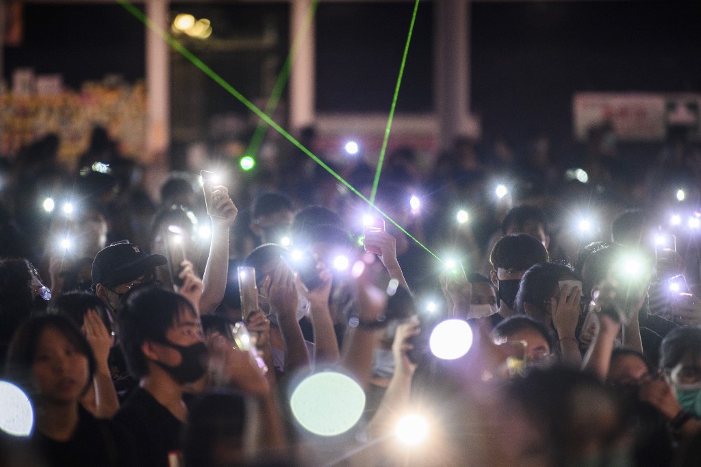 Secondary school students hold up their phone torches as they sing 'Do You Hear the People Sing' from 'Les Miserables' while attending a rally at Edinburgh Place in Hong Kong on August 22, 2019. - Hong Kong student leaders on Thursday announced a two-week boycott of lectures from the upcoming start of term, as they seek to keep protesters on the streets and pressure on the government. (Photo by Anthony WALLACE / AFP)
