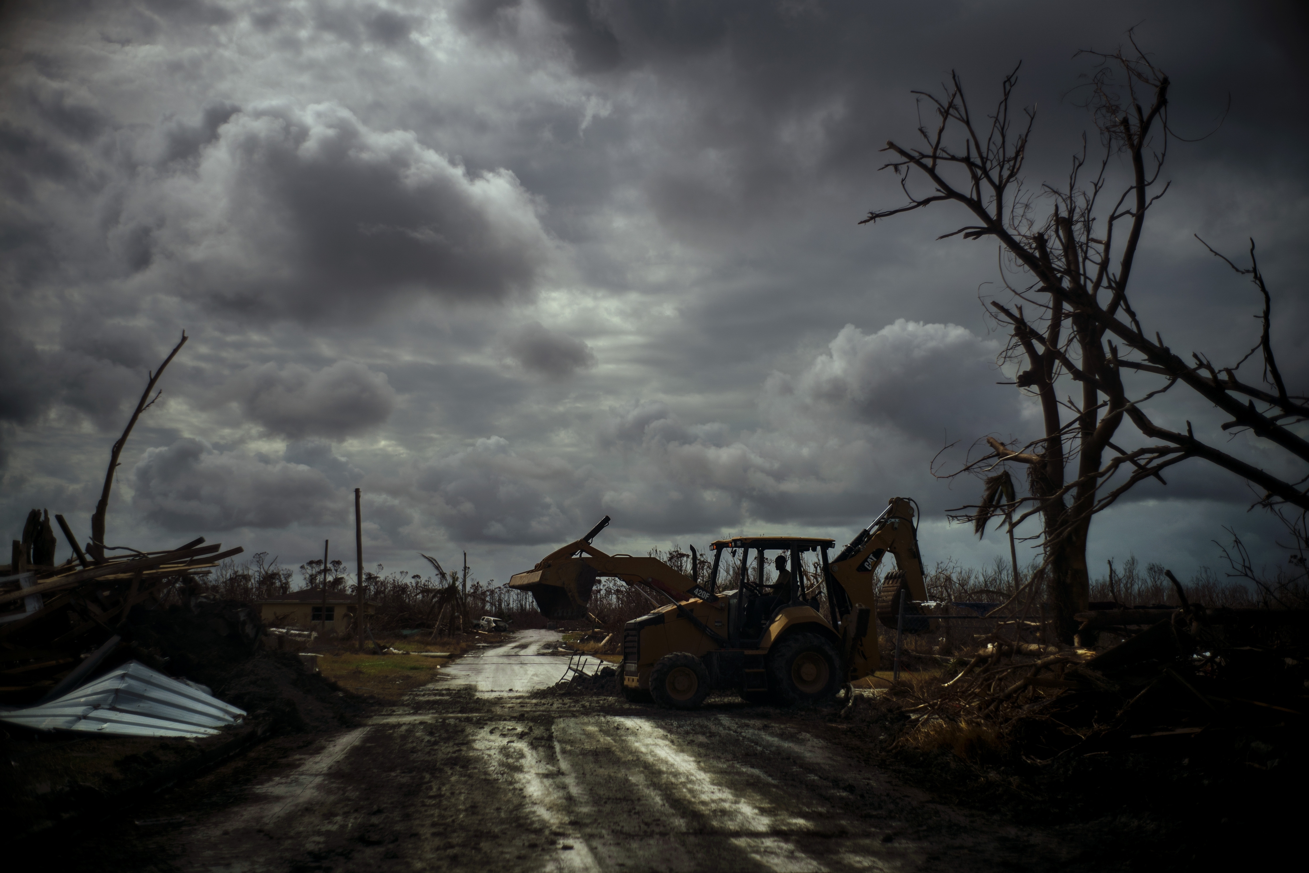 Mos Antenor, 42, drives a bulldozer while clearing the road after Hurricane Dorian Mclean's Town, Grand Bahama, Bahamas, Friday Sept. 13, 2019. (AP Photo/Ramon Espinosa)