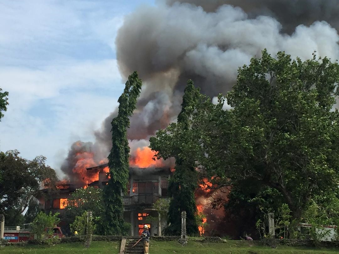 The 83-year-old Gustilo mansion being eaten up by flames on Tuesday. PHOTO BY KHAI ARATES