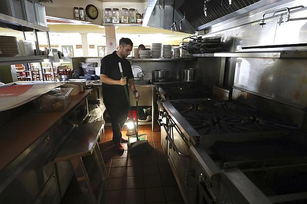 Worker sweeps floor in restaurant in California