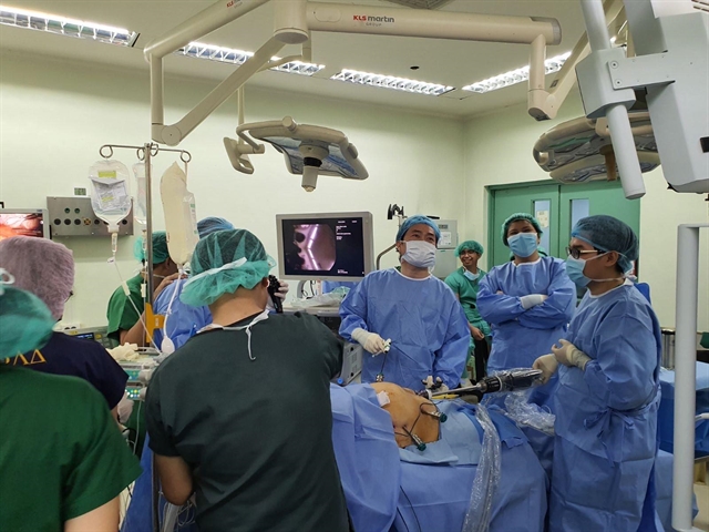 Doctors from the Philippine General Hospital watch doctors from Bình Dân Hospital in HCM City use robots to perform surgeries on two obese patients to remove part of their stomach. Photo courtesy of the Bình Dân Hospital