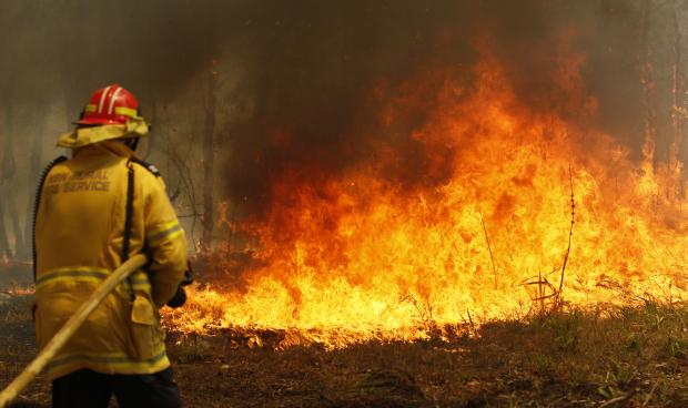 Australian firefighter hosing down wildfire