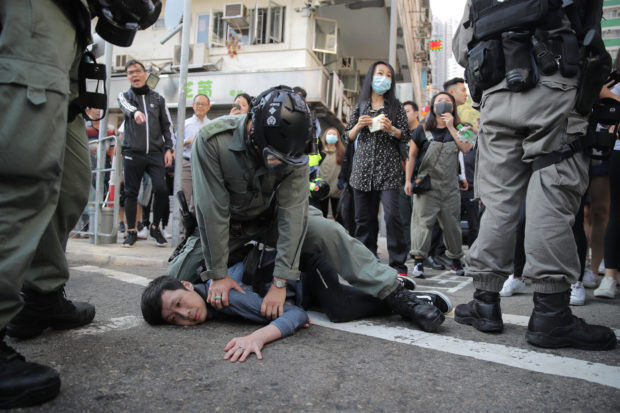 Hong Kong police shoot protester as activists block streets