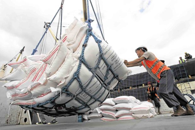 Workers unloading sacks of rice at a port