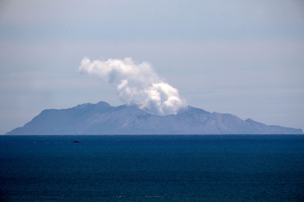 Steam rises from the White Island volcano following the December 9 volcanic eruption, in Whakatane on December 11, 2019. - The smouldering New Zealand volcano that killed at least six people is still too dangerous for emergency teams to recover bodies from, police said on December 11, warning that many tourists who escaped the island were so badly burned they were not yet out of danger. (Photo by Marty MELVILLE / AFP)