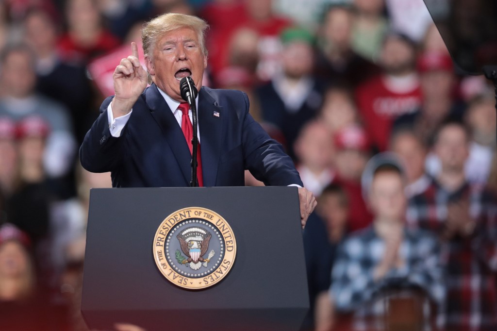 BATTLE CREEK, MICHIGAN - DECEMBER 18: President Donald Trump addresses his impeachment after learning how the vote in the House was divided during a Merry Christmas Rally at the Kellogg Arena on December 18, 2019 in Battle Creek, Michigan. While Trump spoke at the rally the House of Representatives voted, mostly along party lines, to impeach the president for abuse of power and obstruction of Congress, making him just the third president in U.S. history to be impeached.   Scott Olson/Getty Images/AFP