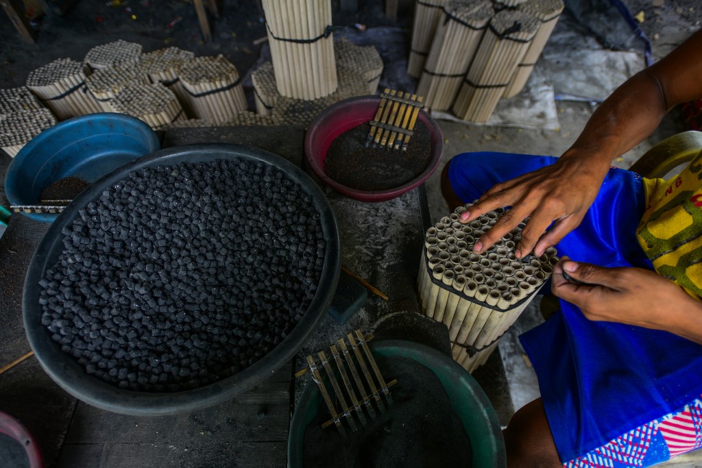 A worker prepares firecrackers for sale in a makeshift factory ahead of New Year celebrations in Bocaue, Bulacan province on December 27, 2019. (Photo by Maria TAN / AFP)