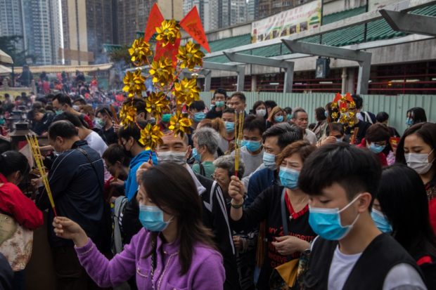 People wear masks as they visit Wong Tai Sin temple on the first day of the Lunar New Year of the Rat in Hong Kong on January 25, 2020, as a preventative measure following a coronavirus outbreak which began in the Chinese city of Wuhan. - Hong Kong on January 25 declared a mystery virus outbreak as an "emergency" -- the city's highest warning tier -- as authorities ramped up measures aimed at reducing the risk of further infections spreading. (Photo by DALE DE LA REY / AFP)