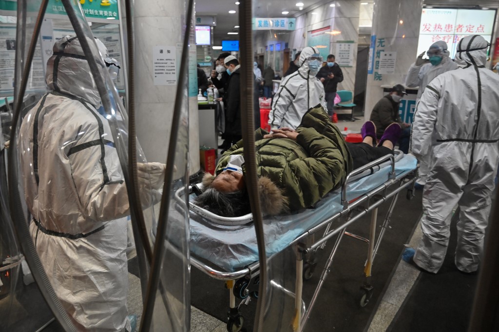Medical staff members wearing protective clothing to help stop the spread of a deadly virus which began in the city, arrive with a patient at the Wuhan Red Cross Hospital in Wuhan on January 25, 2020. - The Chinese army deployed medical specialists on January 25 to the epicentre of a spiralling viral outbreak that has killed 41 people and spread around the world, as millions spent their normally festive Lunar New Year holiday under lockdown. (Photo by Hector RETAMAL / AFP)