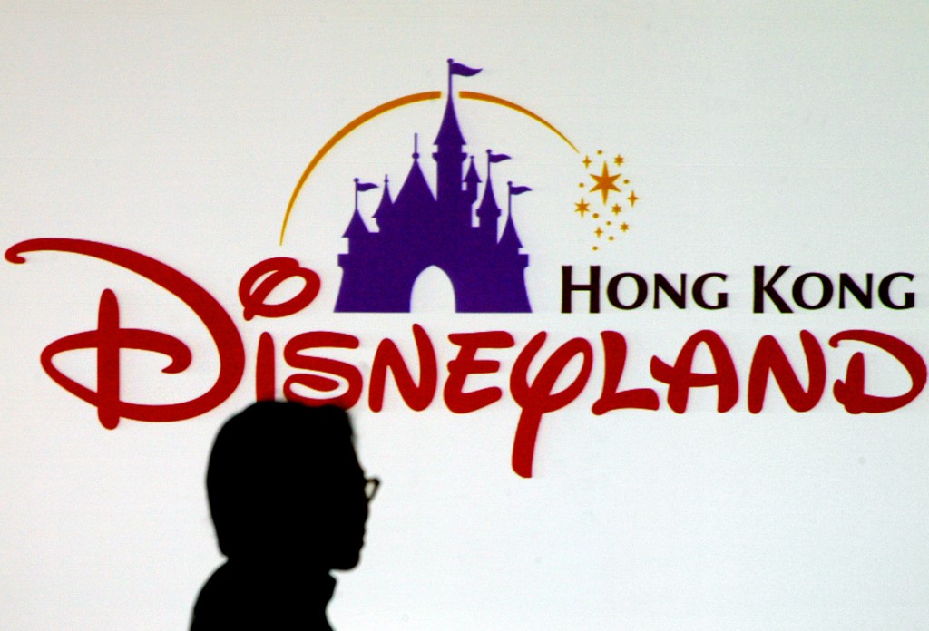 (FILES) This file photo taken on November 22, 2004 shows a journalist standing in front of the Hong Kong Disneyland theme park logo prior to a press conference in Hong Kong. - Hong Kong's Disneyland announced it was shutting its doors on January 26, 2020 until further notice over the deadly virus outbreak in central China, a day after city authorities classified the crisis as an emergency. (Photo by Philippe LOPEZ / AFP)