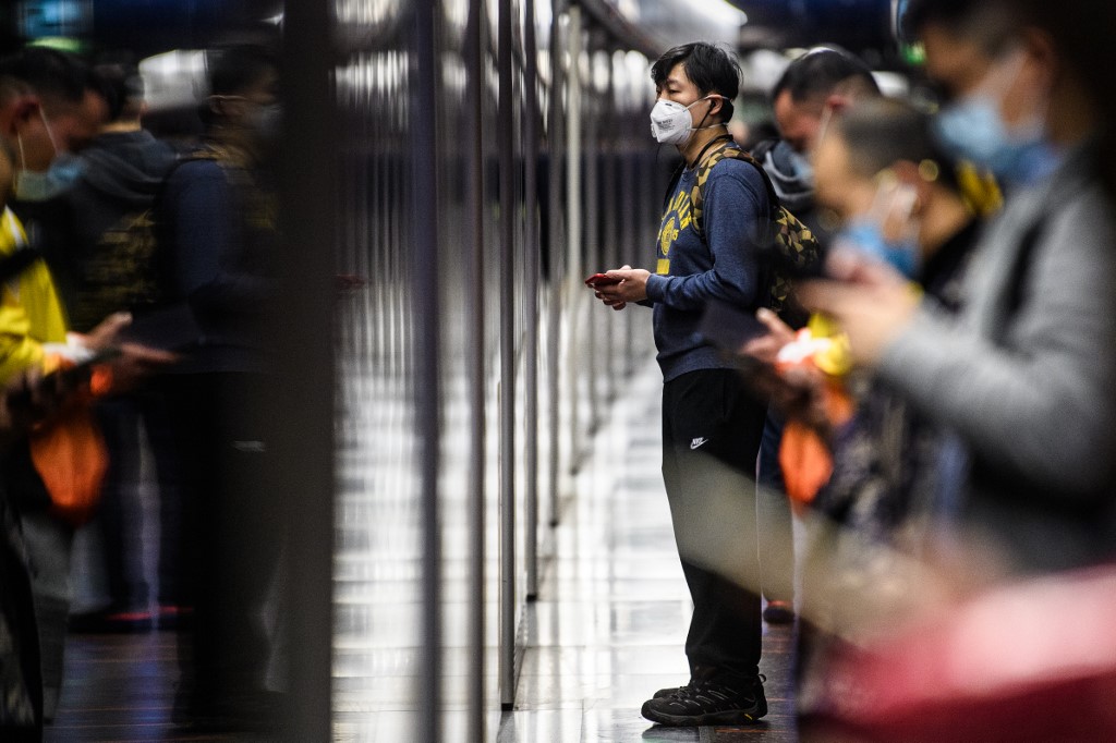 Passengers wearing face masks wait on the platform in a MTR underground metro train during a Lunar New Year of the Rat public holiday in Hong Kong on January 27, 2020, as a preventative measure following a coronavirus outbreak which began in the Chinese city of Wuhan. (Photo by Anthony WALLACE / AFP)