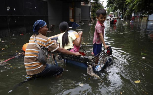 Jakarta residents wading through a flooded street