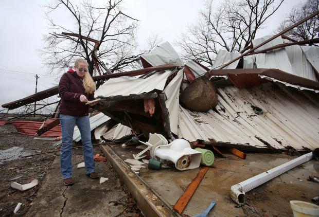 Scarlett Faulk beside building destroyed by storm