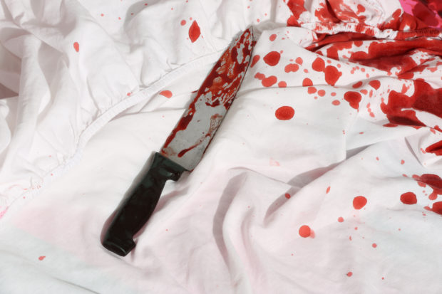 Bloody Knife on white bed sheets