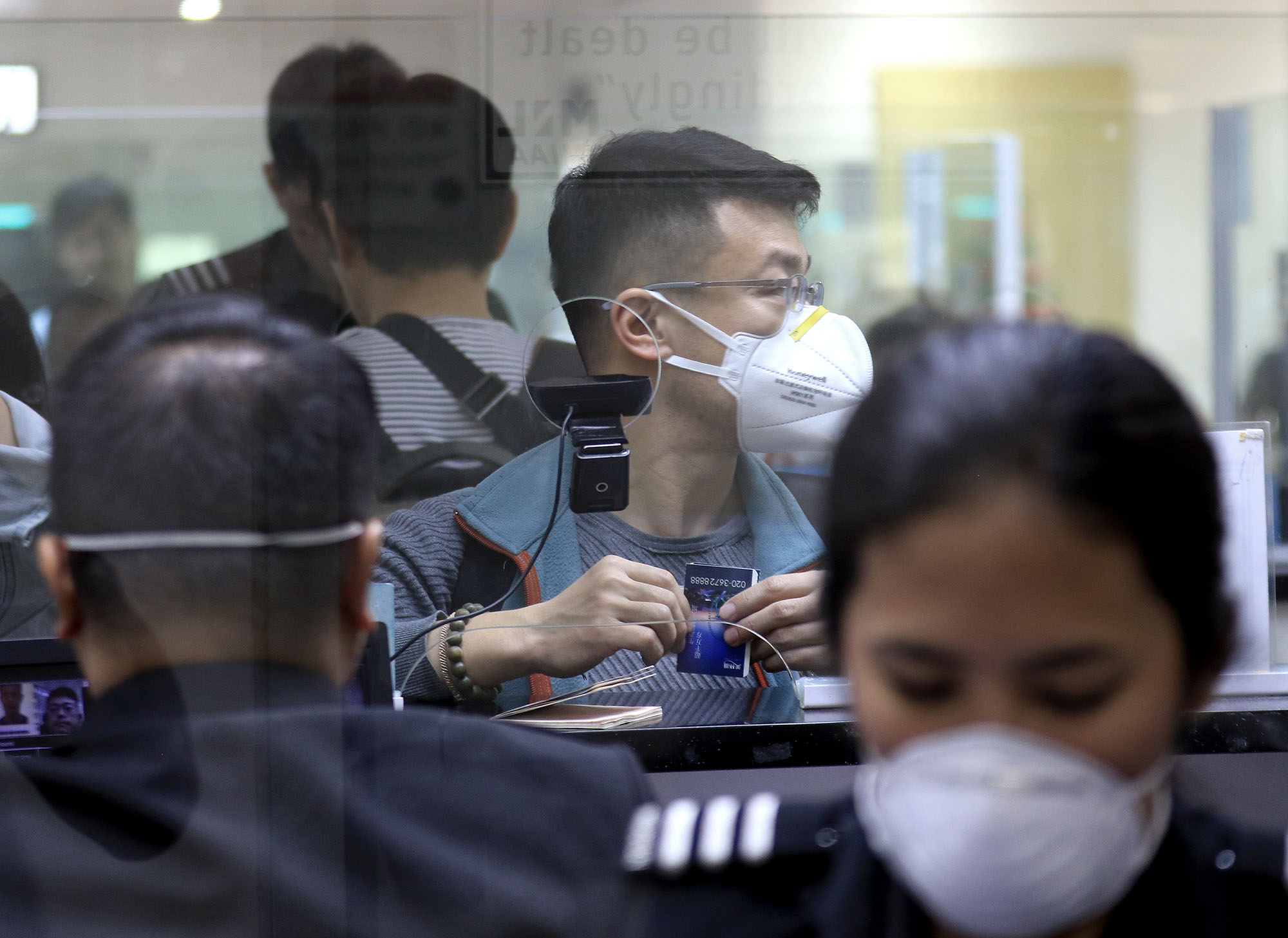 LINES OF DEFENSE Passengers arriving on international flights wear surgical masks as they face immigration officers at Ninoy Aquino International Airport Terminal 1 in Pasay City, where measures are in place to monitor possible carriers of the new and deadly coronavirus strain. —RICHARD A. REYES coronavirus