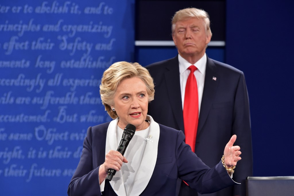 (FILES) In this file photo taken on October 9, 2016 Republican presidential candidate Donald Trump listens to Democratic presidential candidate Hillary Clinton during the second presidential debate at Washington University in St. Louis, Missouri. - When Donald Trump literally belittles his perceived enemies -- by mocking their stature -- he is weaponizing a long-standing maxim of US presidential politics: taller guys tend to win the White House. Trump -- who stands at about 6'3" (1m90) depending on which source you use -- has hammered away of late at Mike Bloomberg, the former New York mayor whose campaign for the Democratic nomination is gathering pace. (Photo by Paul J. RICHARDS / AFP)