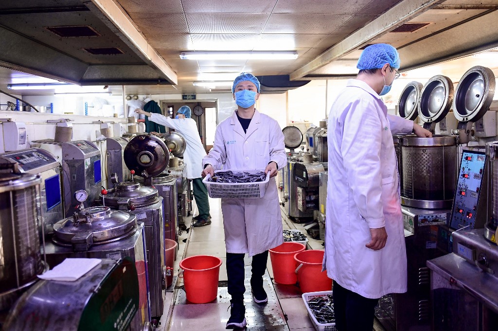 This photo taken on February 20, 2020 shows a medical worker holding bags of liquid traditional Chinese medicine at a hospital in Shenyang in China's northeastern Liaoning province. - The death toll in China from the coronavirus epidemic rose to 2,236 on February 21 after 118 more people died, most of them in the hard-hit epicentre province of Hubei, the government said. (Photo by STR / AFP) / China OUT